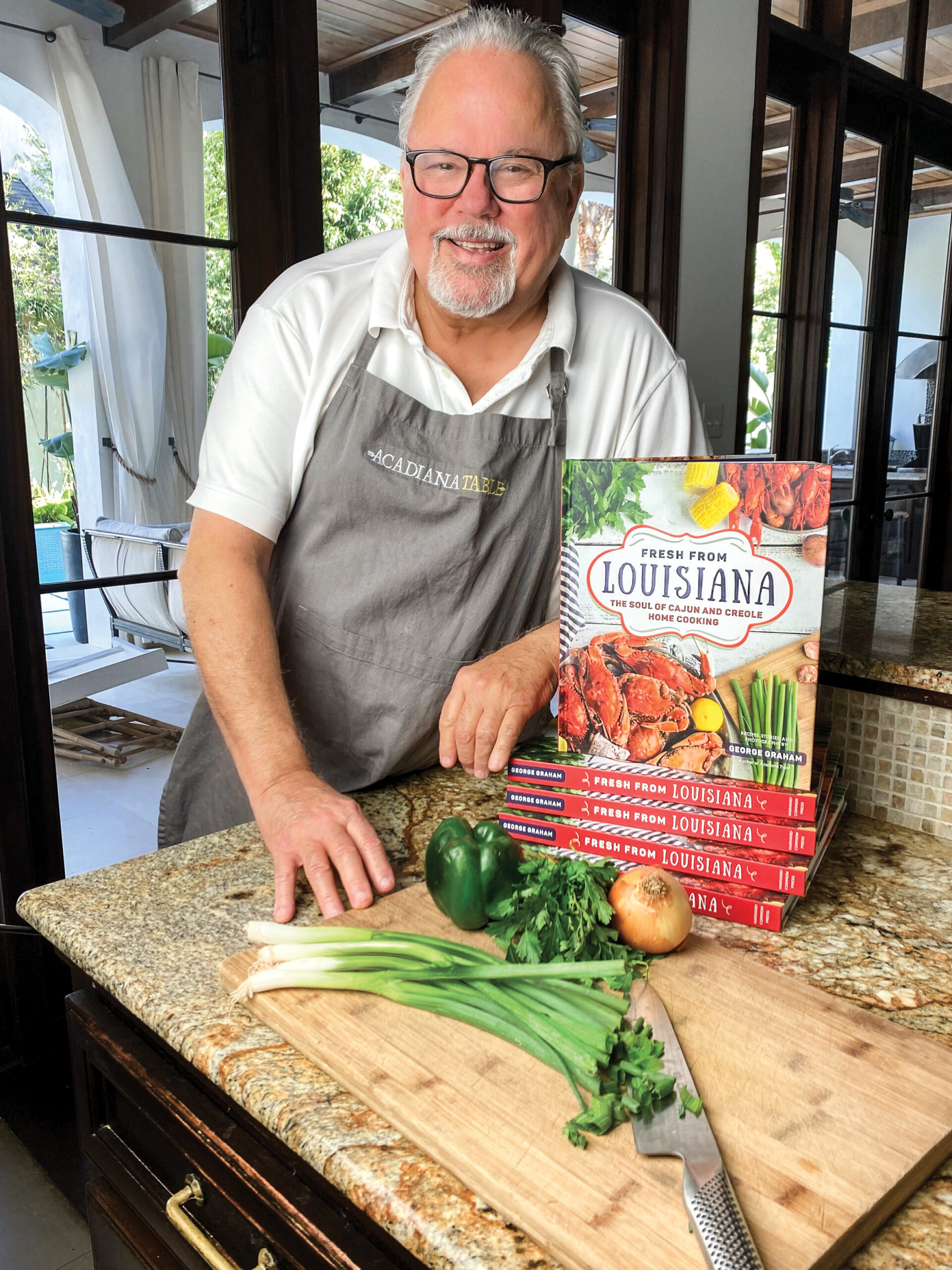 A Love Letter to Louisiana: Recipes and Memories from Fresh from Louisiana - Louisiana Cookin'  George graham standing in front of cookbook display
