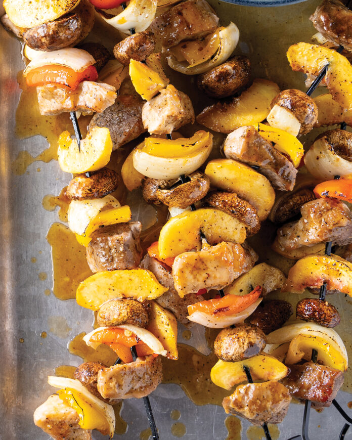 web-Venison-Kabobs786JB Skewers of grilled chicken, yellow peppers, onions, and mushrooms resting on a metal tray with juices pooling beneath.