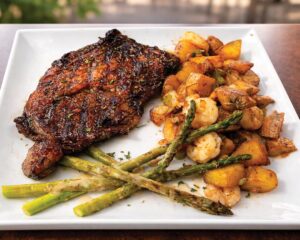 New + Interesting May/June 2026 - Louisiana Cookin' Catch up on all the latest happenings across the Bayou State, with must-try restaurants and so much more. Juicy glazed steak with roasted potatoes and asparagus on a white plate.