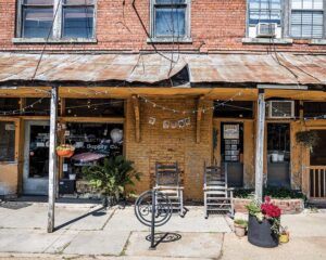 Weekend Away: Clarksdale, Mississippi - Louisiana Cookin' Set your sights on the Mississippi Delta for a soulful few days. Rustic brick storefront with a rusted corrugated metal awning, string lights, and two wooden chairs on the sidewalk amid potted plants.