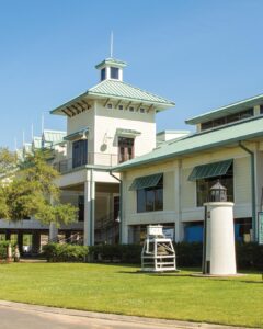 Worth the Drive: Small Towns with Big Charm - Louisiana Cookin'  White two-story building with a green roof and a small lighthouse-style tower against a clear blue sky; manicured lawn in front.