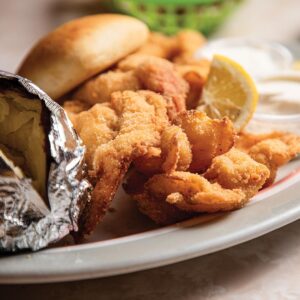 Weekend Away: Clarksdale, Mississippi - Louisiana Cookin' Set your sights on the Mississippi Delta for a soulful few days. Plate of fried seafood with lemon wedge and hush puppies on a white plate.