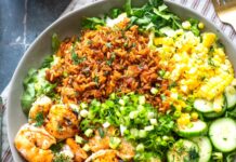 Back-to-School Meals with a Creole Twist Shrimp and greens salad with corn, cucumber, scallions, and cilantro on a bowl of mixed greens and rice.