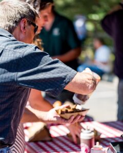 America 250: A Guide to Louisiana’s Semiquincentennial Celebrations - Louisiana Cookin' Join communities across Louisiana as they commemorate a landmark milestone for the nation, the 250th Anniversary of the signing of the Declaration of Independence, with can't-miss patriotic celebrations, historical moments, and service-oriented initiatives. Man pouring sauce on a tray of nachos at an outdoor table with a red-and-white checkered cloth.