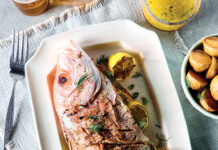 From Tide to Table: 5 Seafood Recipes for Summer Whole roasted fish on a white platter with lemon wedges and fresh herbs (dill) garnish.