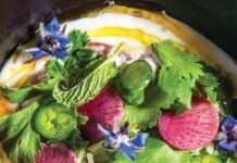 Tuna with Coconut & Jerk Peanuts Colorful herb salad with pink radish slices, green herbs, and blue edible flowers atop a creamy base in a bowl